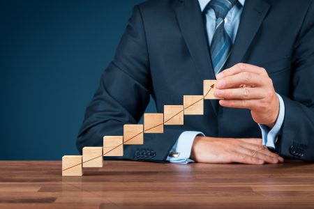 Businessman with wooden cubes with increasing graph