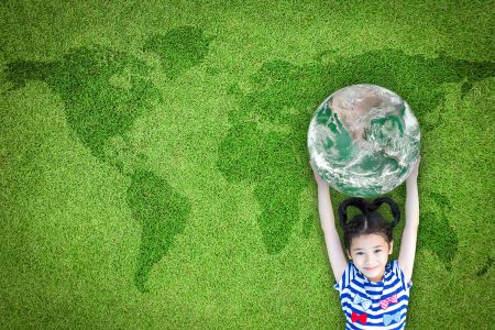Sustainable world environment and CSR with people campaign concept with girl kid raising earth on green lawn: Element of the image furnished by NASA