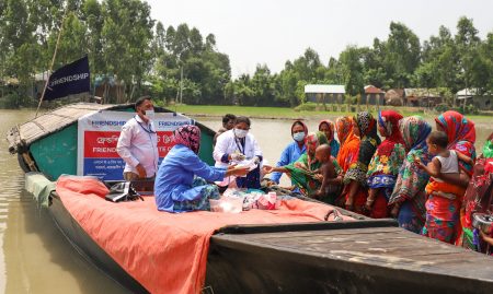 A mobile medical team of Friendship on a boat and a queue of female patients