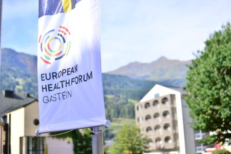 The EHFG flag before a hotel and the mountains in Bad Hofgastein
