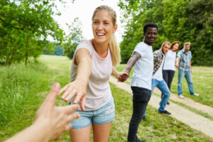 Group of students hold hands as teambuilding exercise in nature